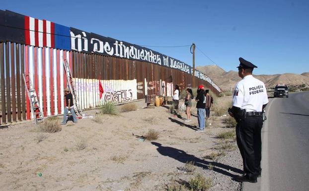 Un policía federal vigila un muro en Ciudad Juárez. /HÉRIKA MARTÍNEZ (Afp)
