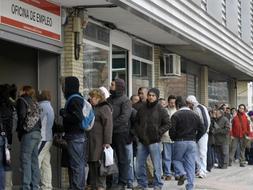 Decenas de personas esperan a las puertas de una oficina de empleo en Madrid./ Afp/
