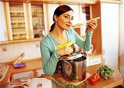 Una mujer prueba un guiso. / MujerHoy.com/