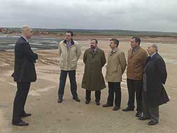 Responsables de Samca, el consejero de Industria y el alcalde garrovillano, en el lugar de la planta. |BRÍGIDO/