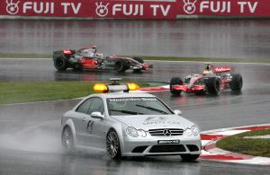 Hamilton y Alonso, custodiados por el coche de seguridad en el Gran Premio de Japón. / EFE/