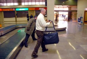 Dos viajeros recogen su equipaje en el Aeropuerto de Badajoz tras llegar el vuelo proveniente de Madrid. / CASIMIRO MORENO/