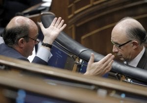 El ministro de Economía, Luis de Guindos, charla en el Congreso con su homólogo de Hacienda, Cristóbal Montoro. ::
CHEMA MOYA / EFE/