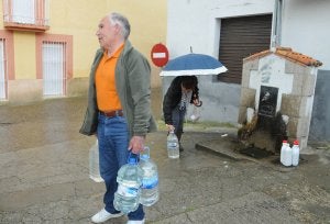 Martín Caballero lleva al menos 40 años llenando sus garrafas en la fuente torrejoncillana de San Francisco. :: PALMA/