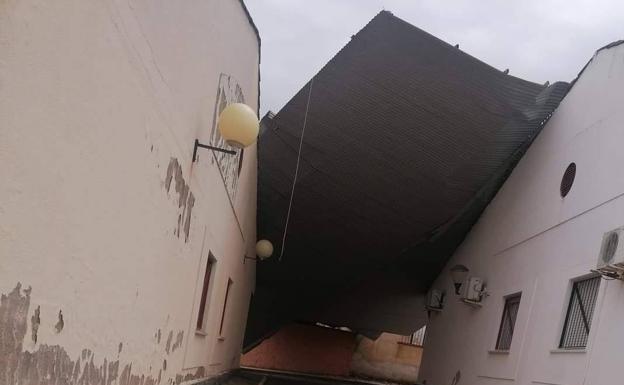 El viento arranca el techo de chapa de una nave industrial en Villalba de los Barros y cae sobre una calle