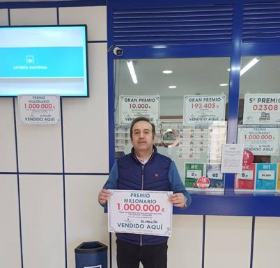 Enrique Castilla, el administrador de loterías que dio el premio, muestra el cartel. /hoy