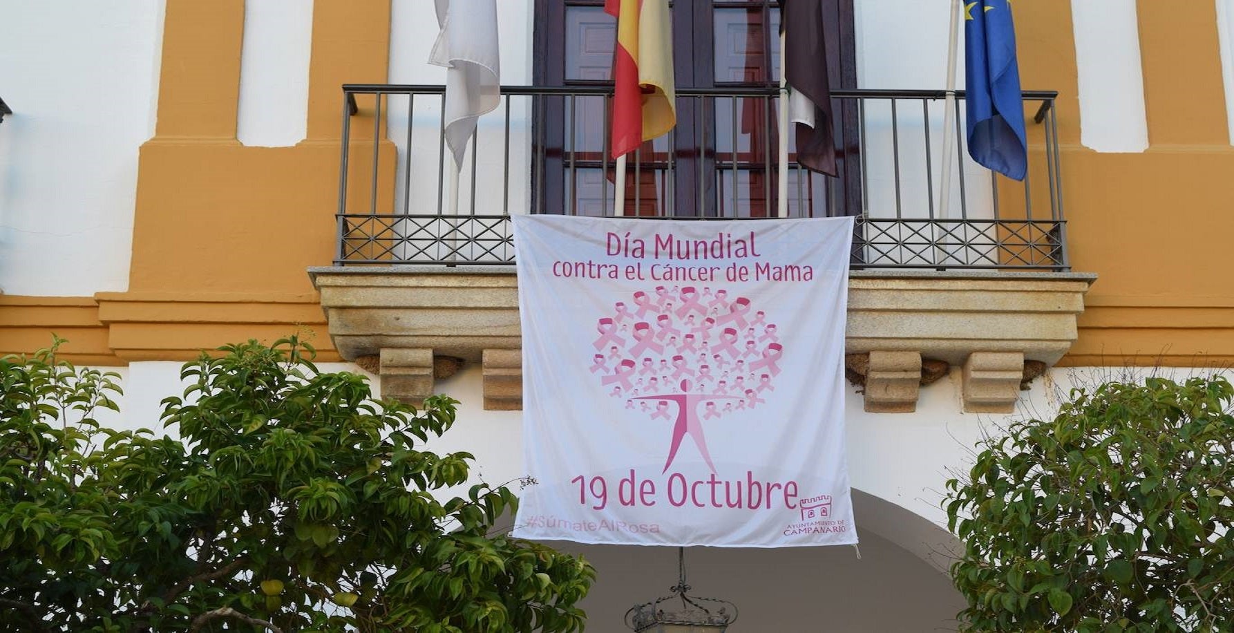 El balcón del ayuntamiento luce una pancarta en apoyo a la lucha contra el cáncer de mama