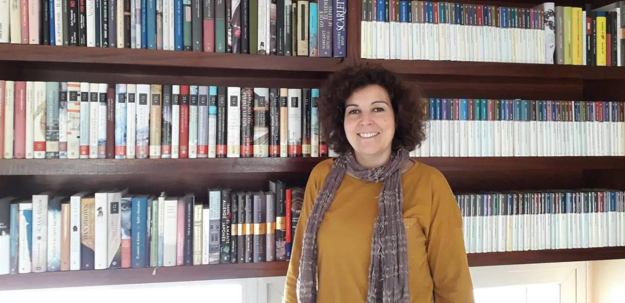 Esmeralda Rodríguez ante la biblioteca personal en su casa, siempre entre libros.