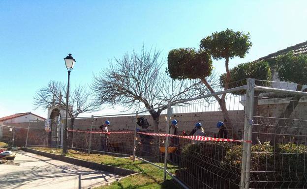 Los alumnos de la escuela profesional adecentan el muro del cementerio