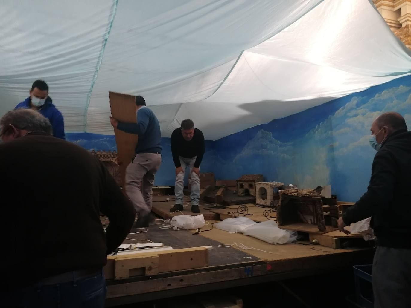 Cinco belenistas trabajan en montar el belén de la Parroquia de Los Santos de Maimona