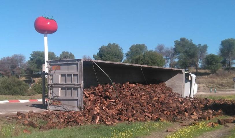 Un camión cargado de leña ha volcado en la rotonda del tomate en Miajadas