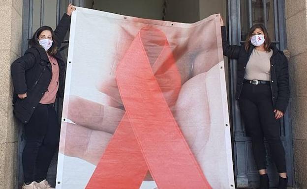 Un lazo rojo preside este martes la fachada del Ayuntamiento de Cáceres