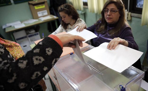 Un mujer deposita su voto en una urna. 