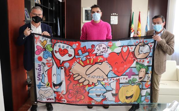 Fernando Sembrador entrega la bandera a los alcaldes de Villanueva y Don Benito. /AV