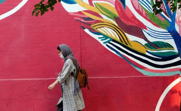Una mujer con mascarilla camina por una calle de Teherán./efe