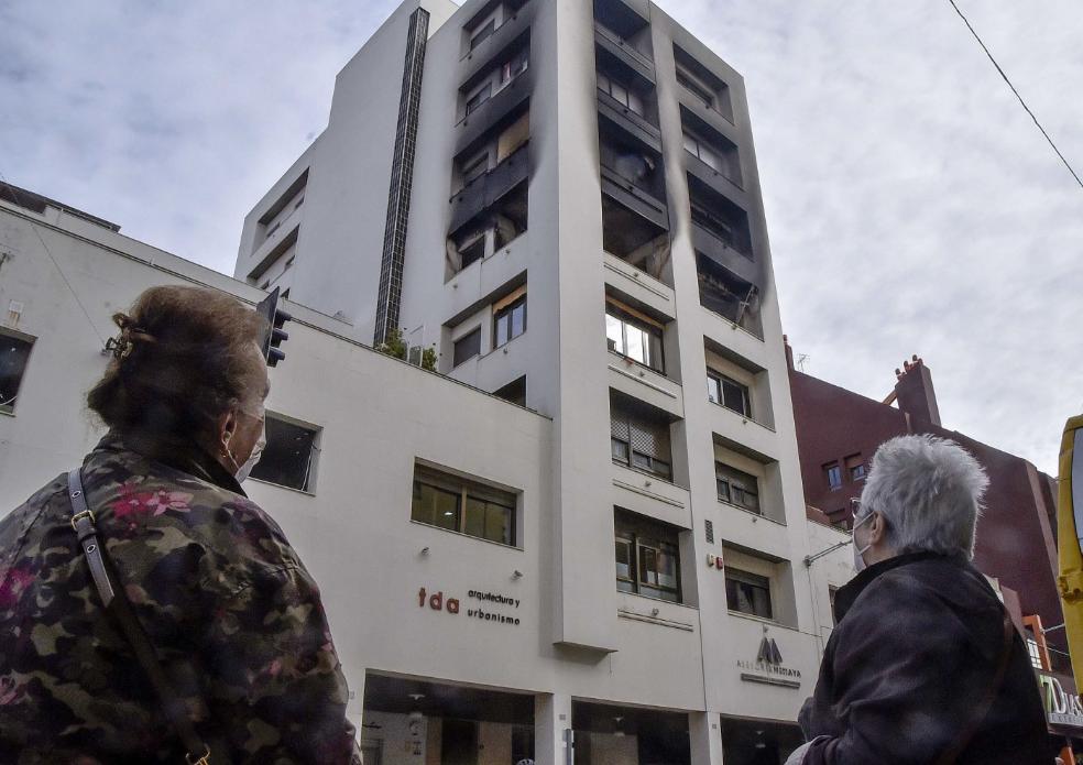 Dos mujeres observan la fachada parcialmente quemada de un edificio de Badajoz, el pasado día 12. / HOY