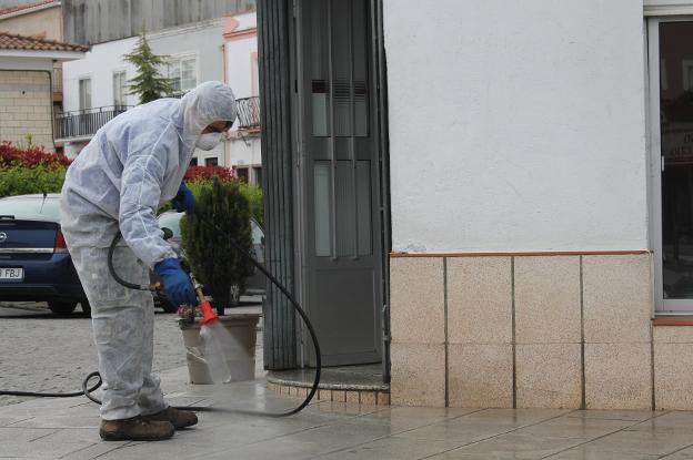 Un operario municipal desinfecta la entrada de un establecimiento. / I.A.