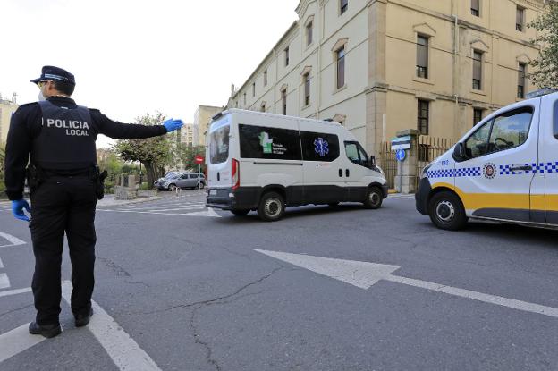 Un policía local controla la entrada de ambulancias con pacientes de coronavirus al Hospital Provincial el 24 de marzo de 2020. / LORENZO CORDERO