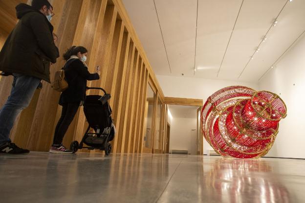 Una familia fotografía la obra 'Descending light', de Ai Weiwei, el viernes en el Museo Helga de Alvear. / J. REY