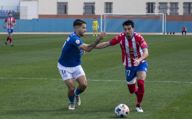 Álex Herrera trata de llevarse el balón en el partido de ayer entre el Melilla y el Don Benito. /ADG