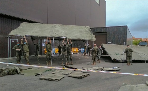 Los militares despliegan toldos en Ifeme para proteger de la lluvia a los que esperan la vacuna