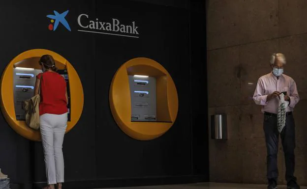 Una clienta utiliza un cajero de CaixaBank, entidad que, tras absorber a Bankia, ha planteado un ERE. /HOY