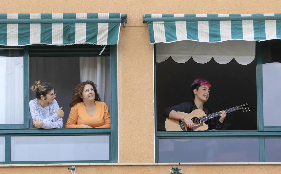 Una vecina toca la guitarra desde su ventana durante el confinamiento. /HOY