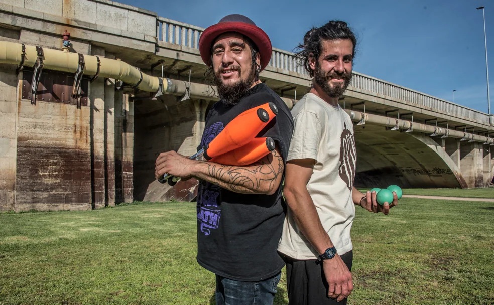 Damián, con las mazas, y Manuel, con las pelotas, practican malabares en el parque del río, junto al puente de la Universidad. /Pakopí