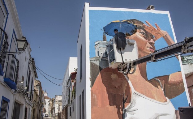 Miguel Tinoco subido a una grúa para pintar su mural en el inicio de la calle Concepción Arenal. /pakopí