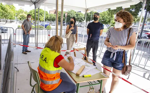 Varios cacereños haciendo cola antes de vacunarse en el Palacio de Congresos de Cáceres./HOY