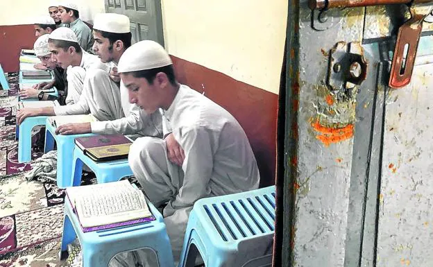 Un grupo de niños intenta memorizar el Coran en un aula de la madrasa./Mikel Ayestaran