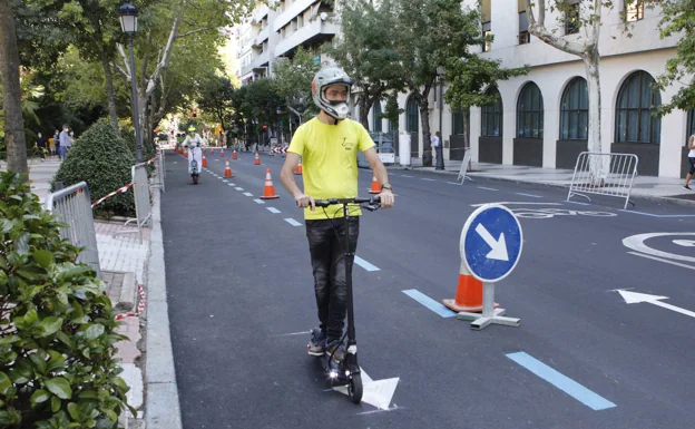 Dos jóvenes con patinetes eléctricos circulando por la avenida de España, vacía de coches, este sábado. /A. MÉNDEZ