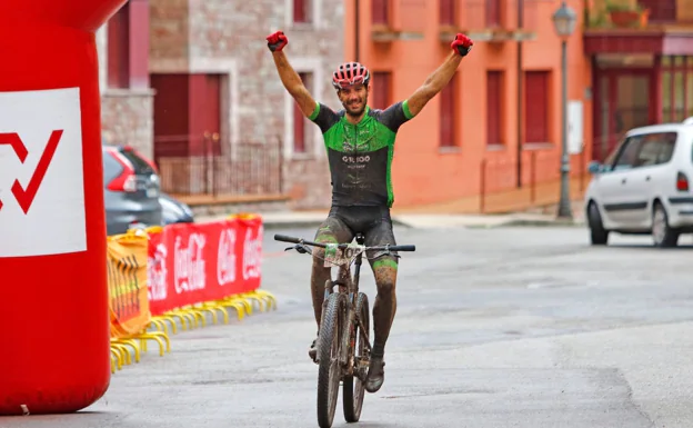 Adrián González levanta los brazos para celebrar su primera victoria  con el Ecopilas en la meta de Somiedo. /@FOTOSCARRERAS.COM