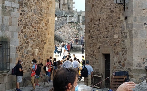 Los turistas visitan una ciudad monumental de Cáceres cercada por los ensayos para el rodaje