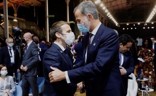 El rey Felipe VI saluda al presidente de Francia, Emmanuel Macron, durante el Foro de París./EFE