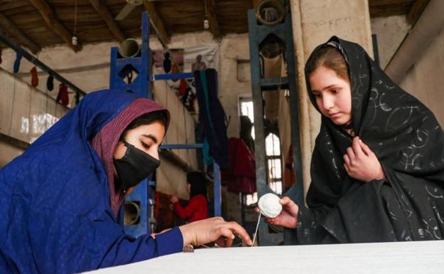 Mujeres afganas tejen alfombras en un taller de la provincia de Herat. /AFP