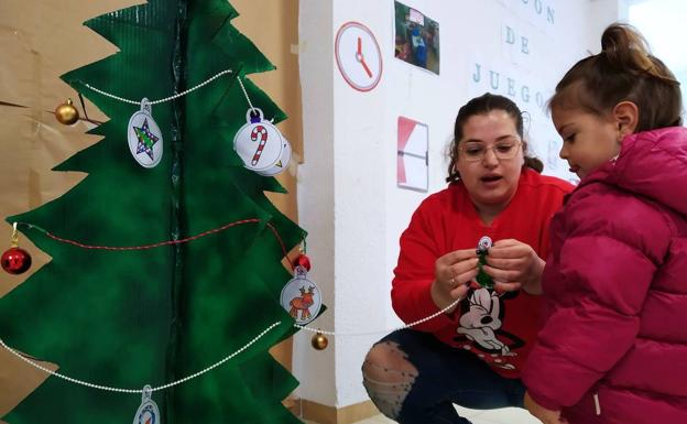 Numerosos niños y niñas decoran abetos de cartón con sus mejores deseos